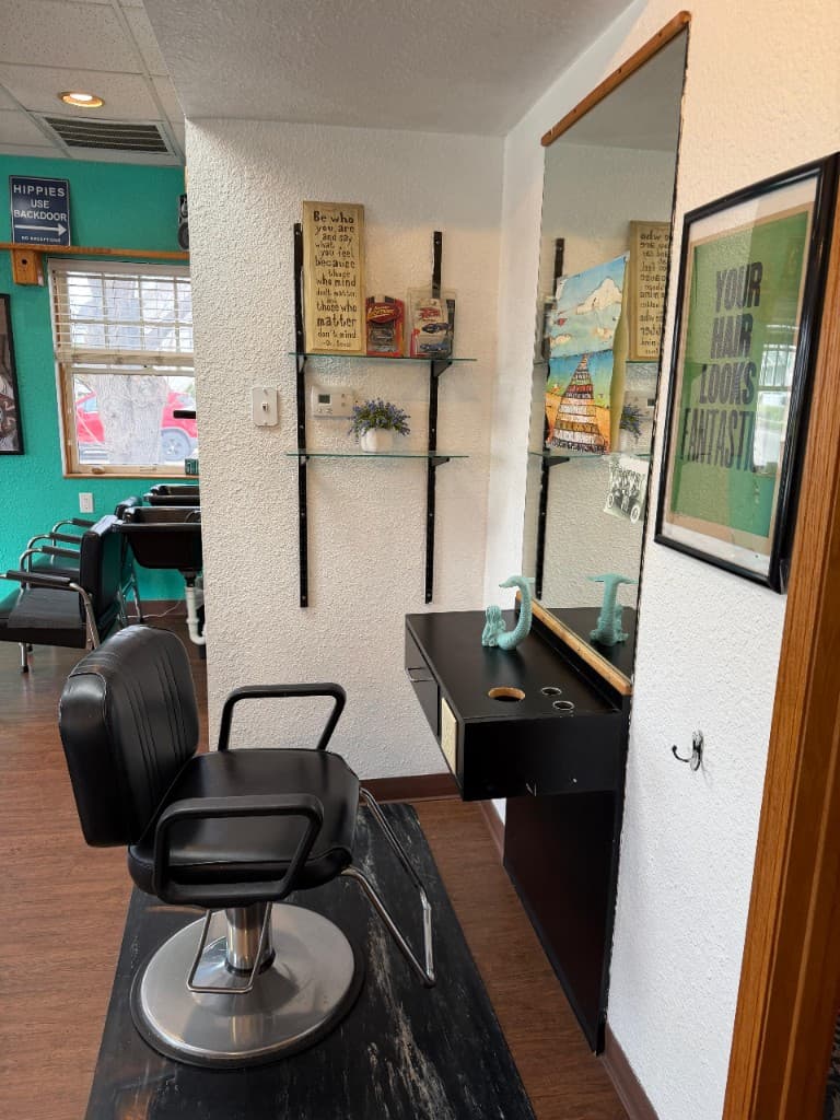 Tangles Salon styling station with mirror, teal accent wall, and professional chair